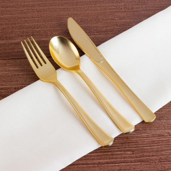 a set of gold glitter disposable flatware on a white napkin