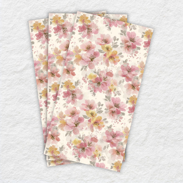 Three floral-patterned paper napkins stacked on a textured white background