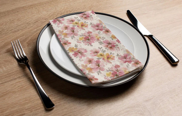 Floral-patterned napkin on a plate with cutlery on a wooden table