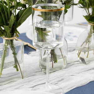 clear and gold plastic wine glasses arranged on a table