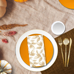 Fall tablescape featuring orange and gold plates, gold cutlery, and leaf-pattern napkins styled for Thanksgiving — Posh Setting.
