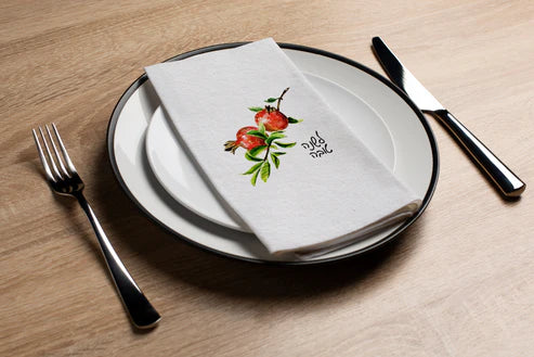 place setting with disposable napkin with shana tova pomegranate design 