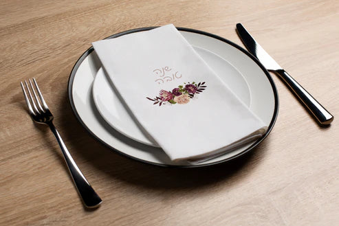 place setting with disposable napkin with shana tova floral design 