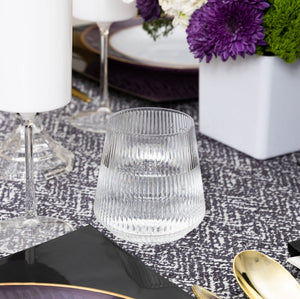 Clear 12 oz plastic stemless ribbed goblet styled on elegant table setting