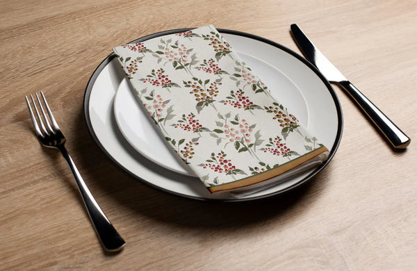 Floral-patterned napkin on a plate with cutlery on a wooden table