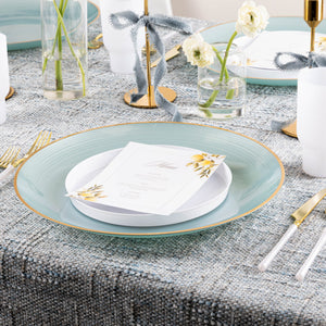 Elegant tablescape featuring an Aqua & Gold Rim Crystal Design charger plate layered with white dinnerware and gold flatware.