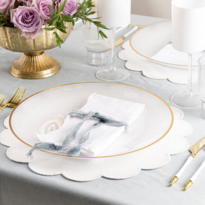 Elegant tablescape featuring a Clear & Gold Rim Crystal Design charger plate styled with white napkins, gold flatware, and floral centerpieces.