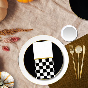 Elegant white, black, and gold disposable dinnerware set styled for a fall or Thanksgiving tablescape with pumpkins, checkered napkin, and gold flatware — Posh Setting.